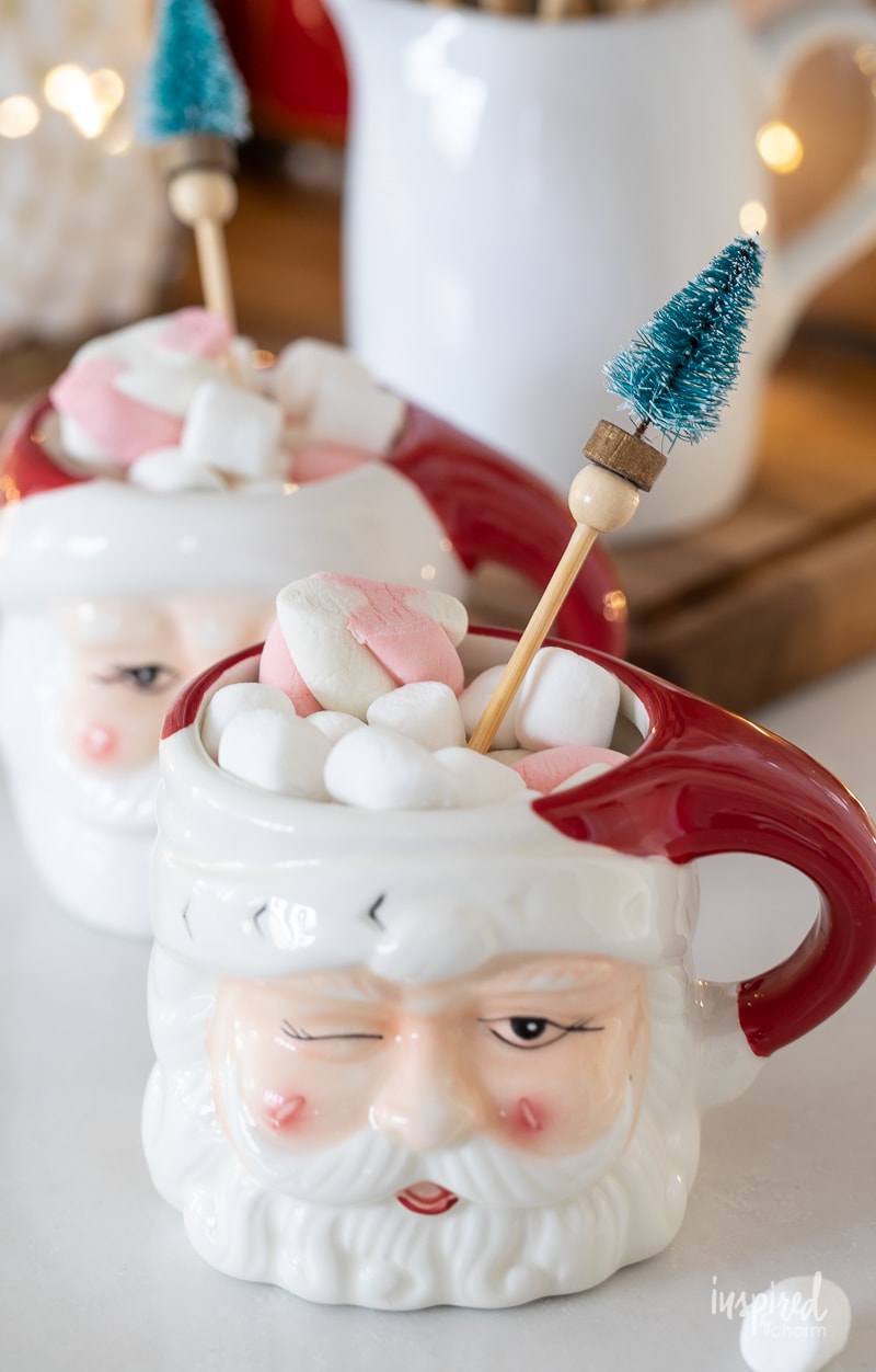DIY Bottle Brush Drink Stirrers in a Santa mug with hot cocoa.