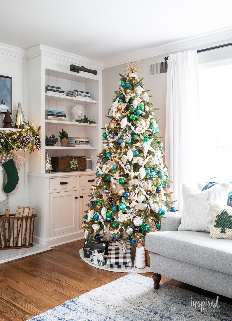 living room with christmas tree in whites and blues and greens. 