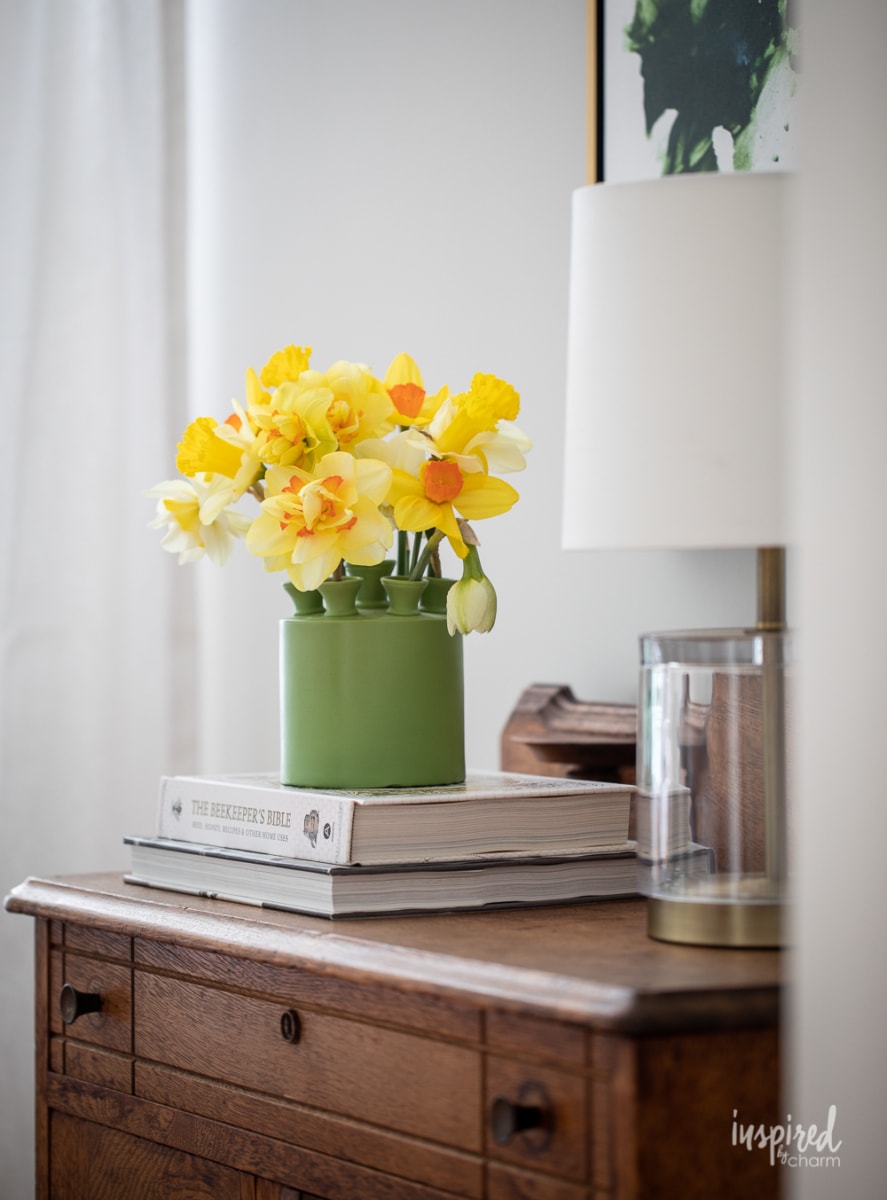 green tulipiere vase with daffodils.