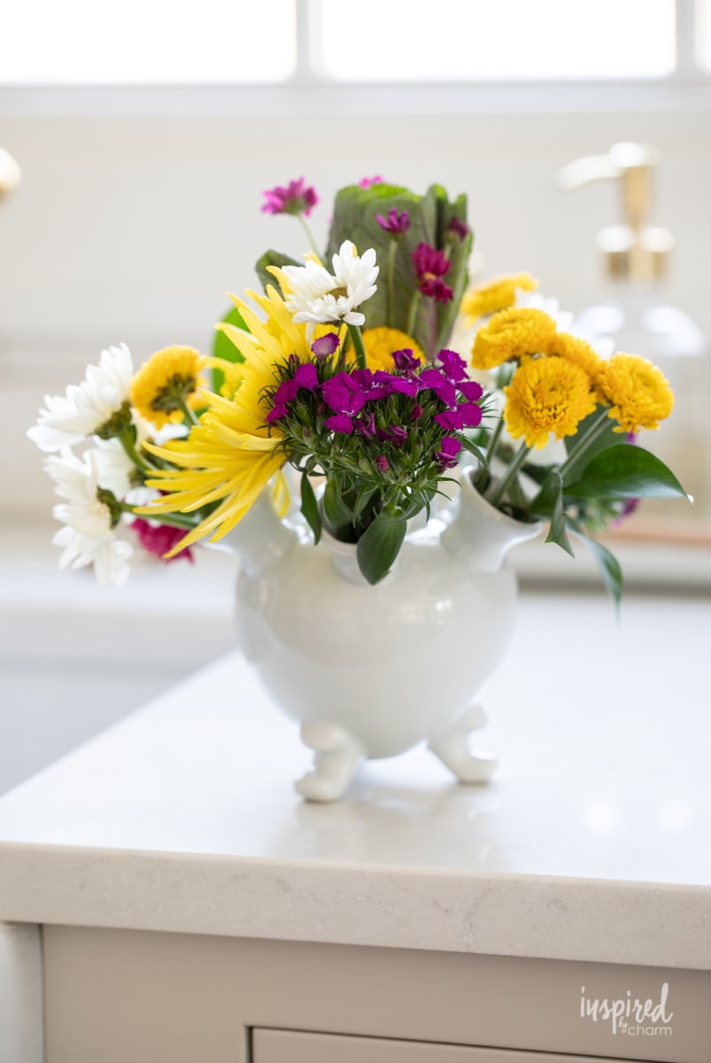 round tulipiere vase with mixed flowers. 
