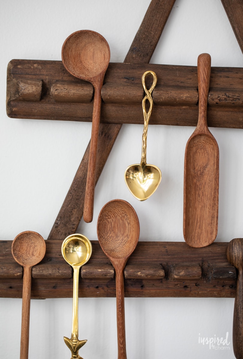 close up of wood and brass spoons hung on a wall. 
