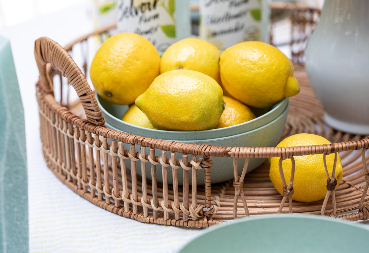 lemons in a bowl in a basket on an outdoor table setting.