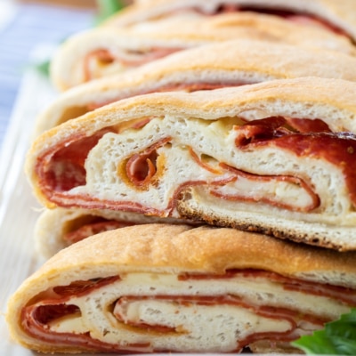 pepperoni bread stacked on a white plate.