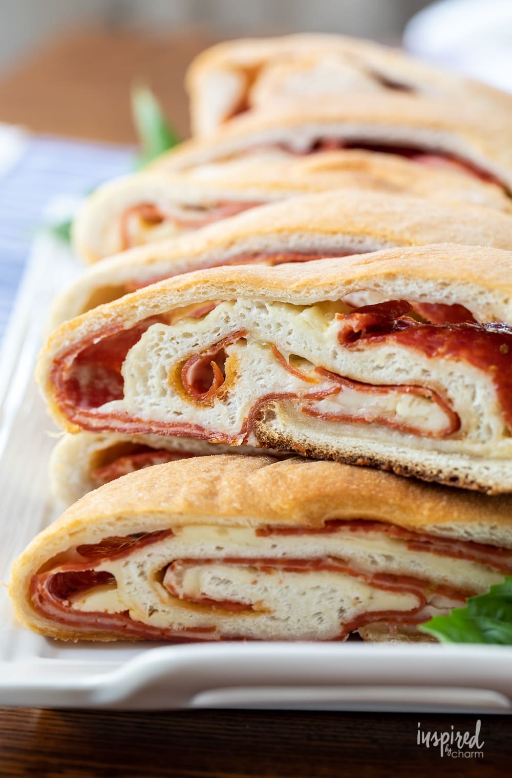 pepperoni bread stacked on a white plate.