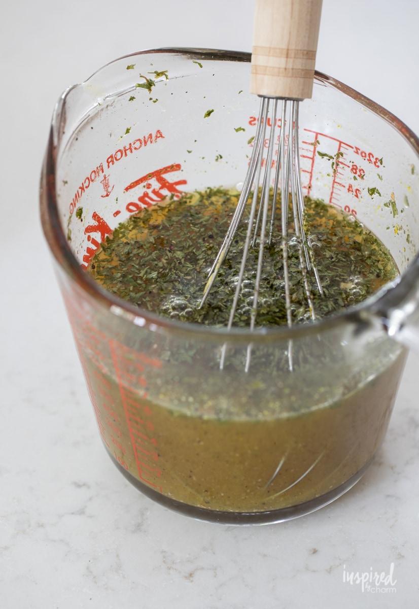 dressing vinaigrette in a measuring cup with a whisk.