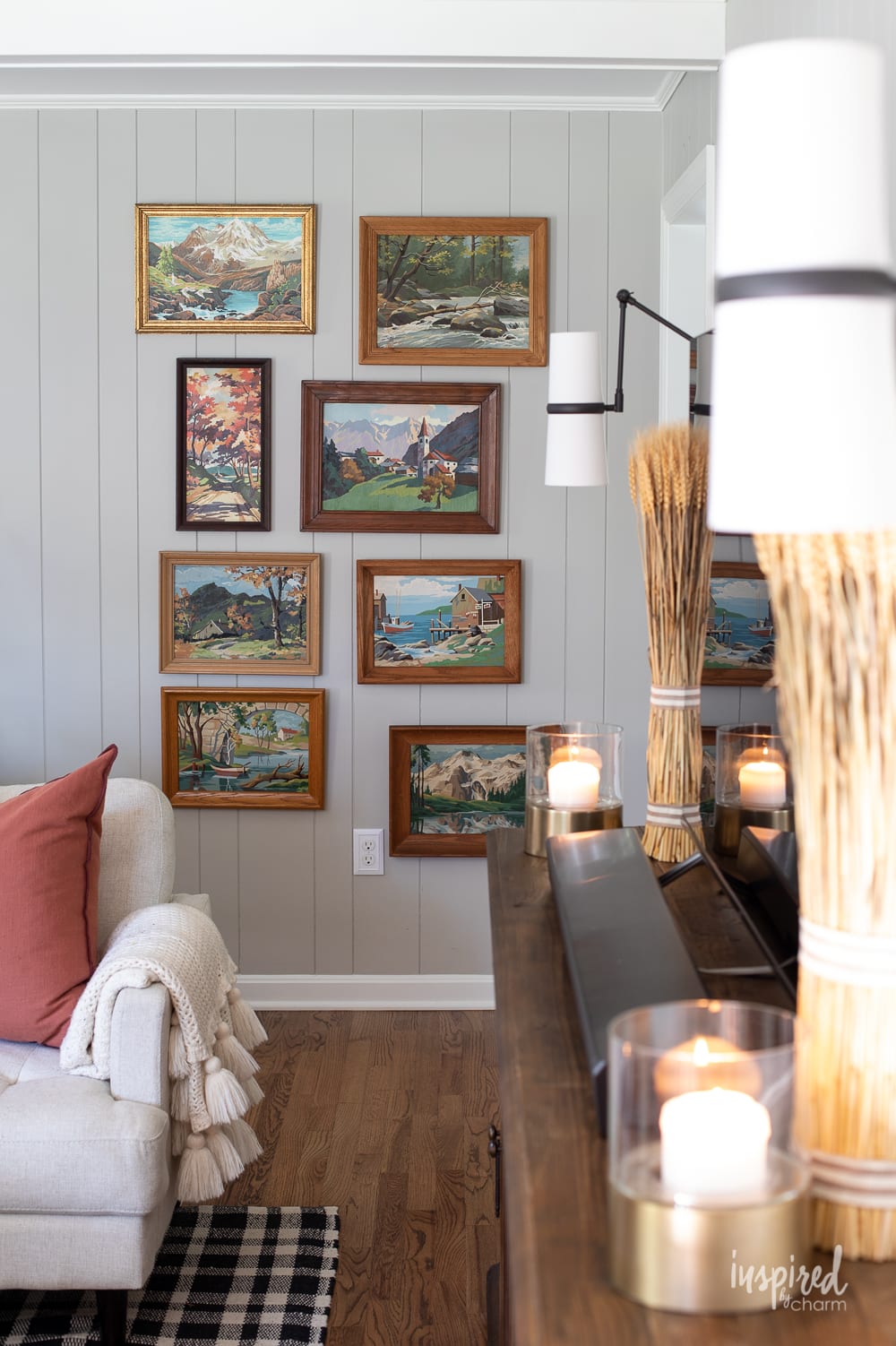 gallery wall of vintage paint by numbers in wood frames.