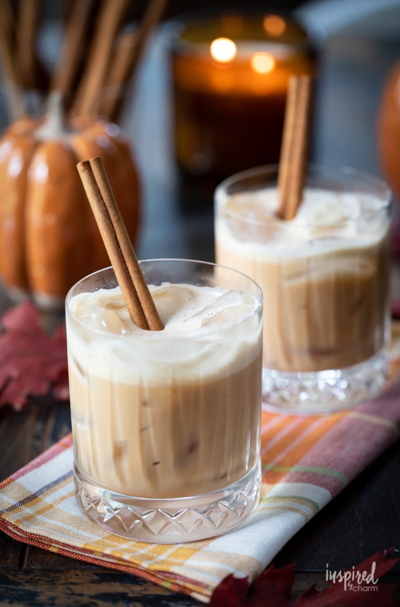 pumpkin spice white Russian halloween cocktails with lit candle in the background