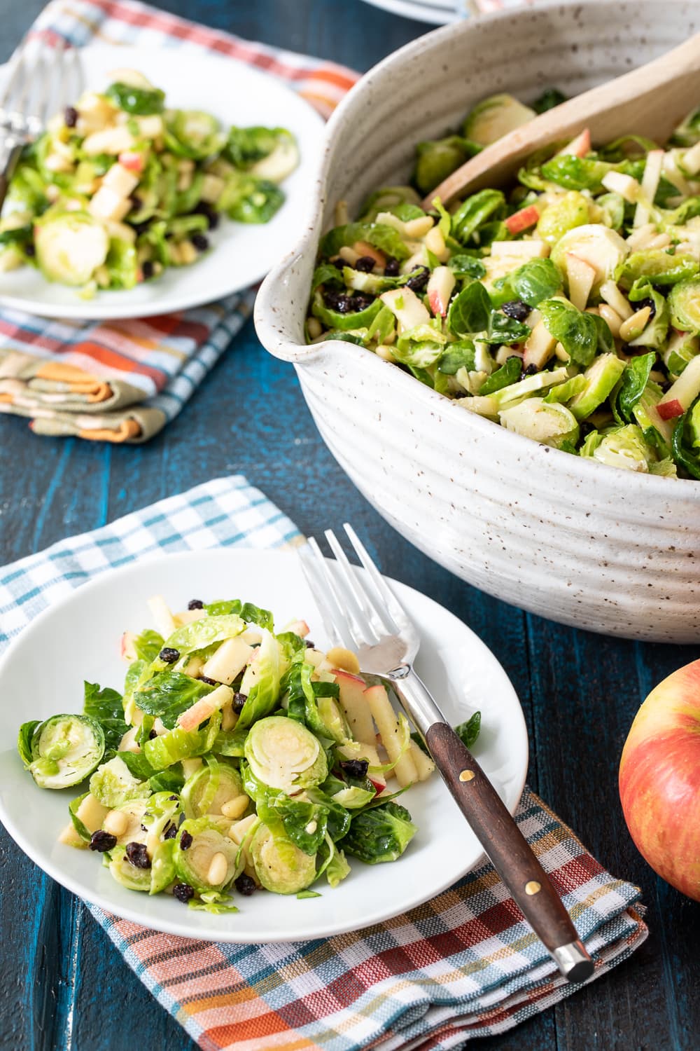 Shaved Brussels Sprout Salad in a big bowl and served on plates. 
