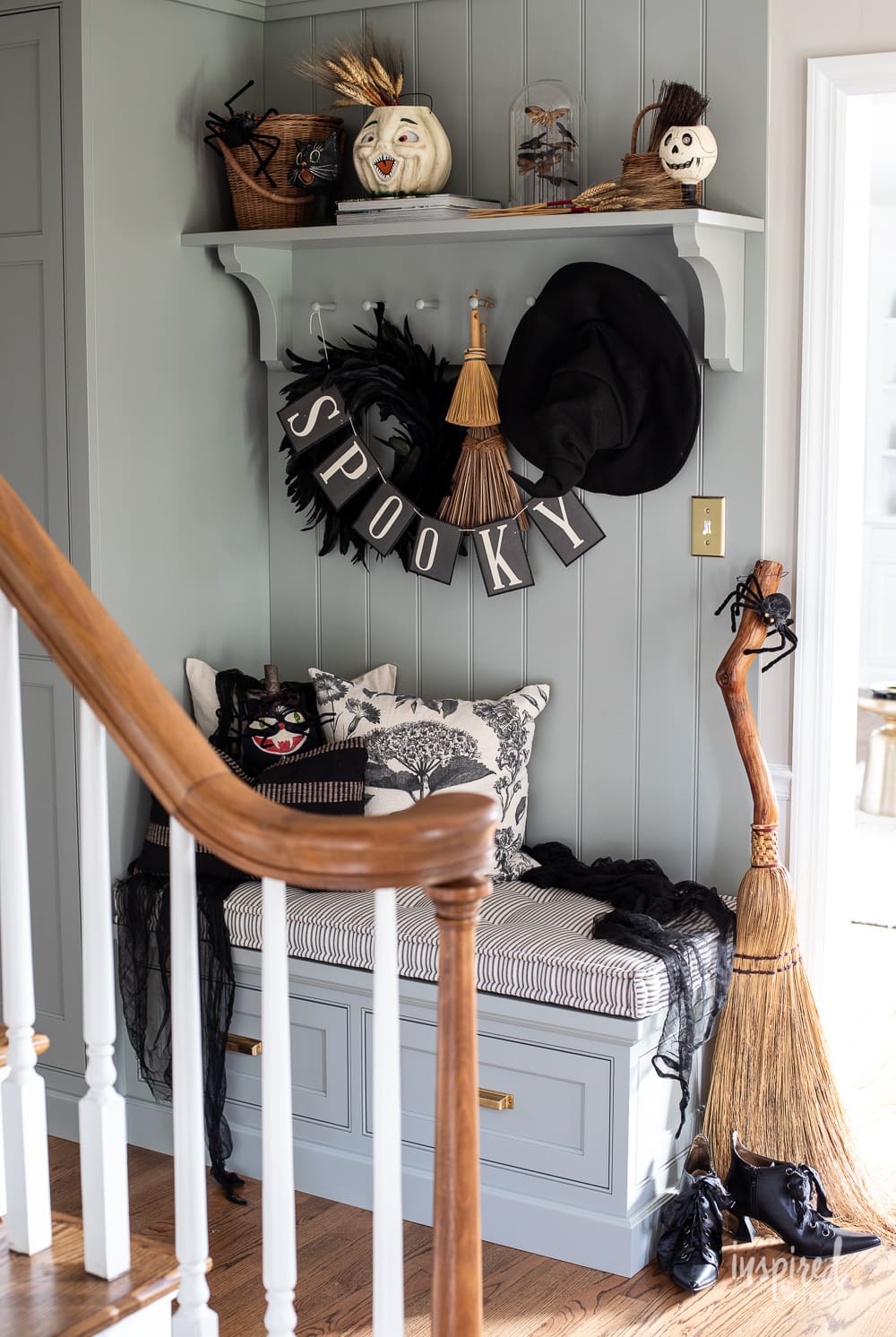 entryway cabinetry styled for halloween with witch inspired items. 