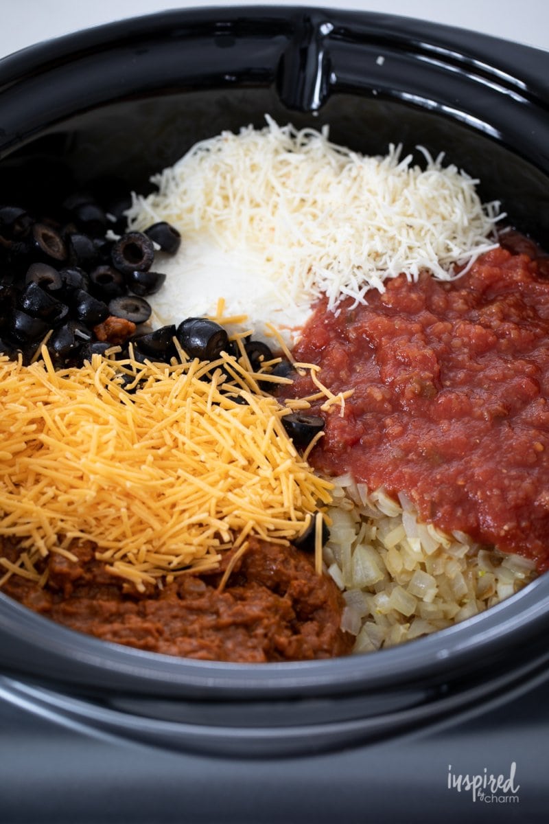 chili, salsa, cheese, olives and onions in slow cooker