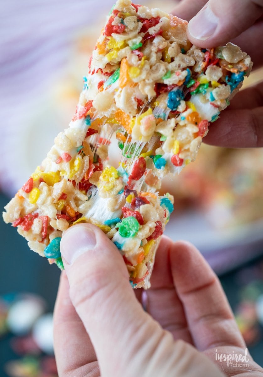 two hand stretching Fruity Pebbles Rice Krispies Treats