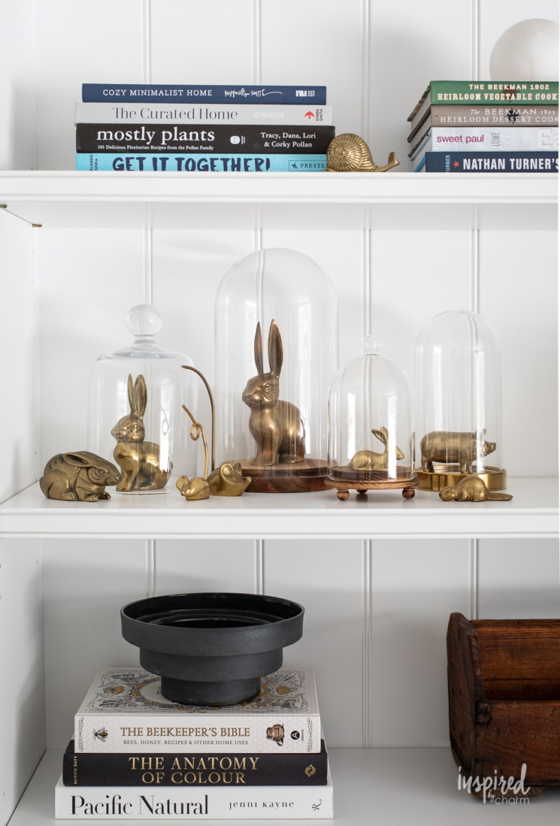 bookcase decor with vintage brass animals