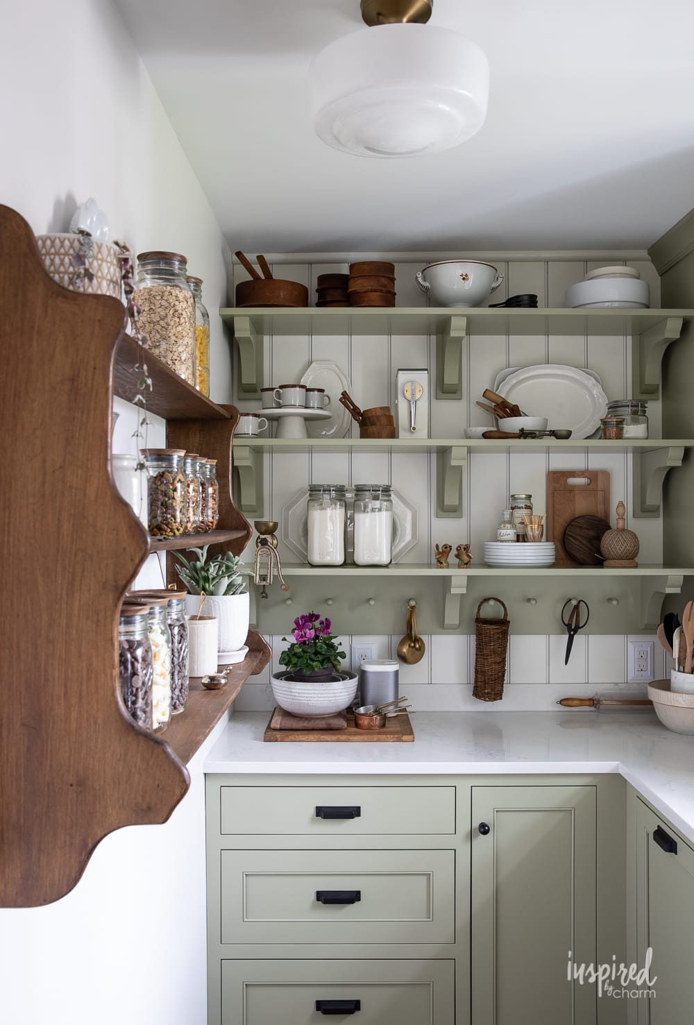 filled butlers pantry with wood shelf on the wall and cabinets and shelves painted Sherwin-Williams sage.