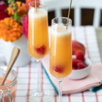 Raspberry Peach Bellinis in glasses on table.