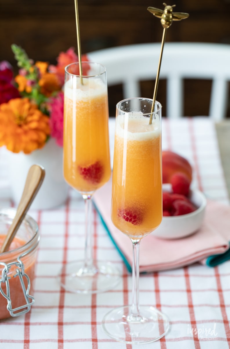 Raspberry Peach Bellinis in glasses on table.