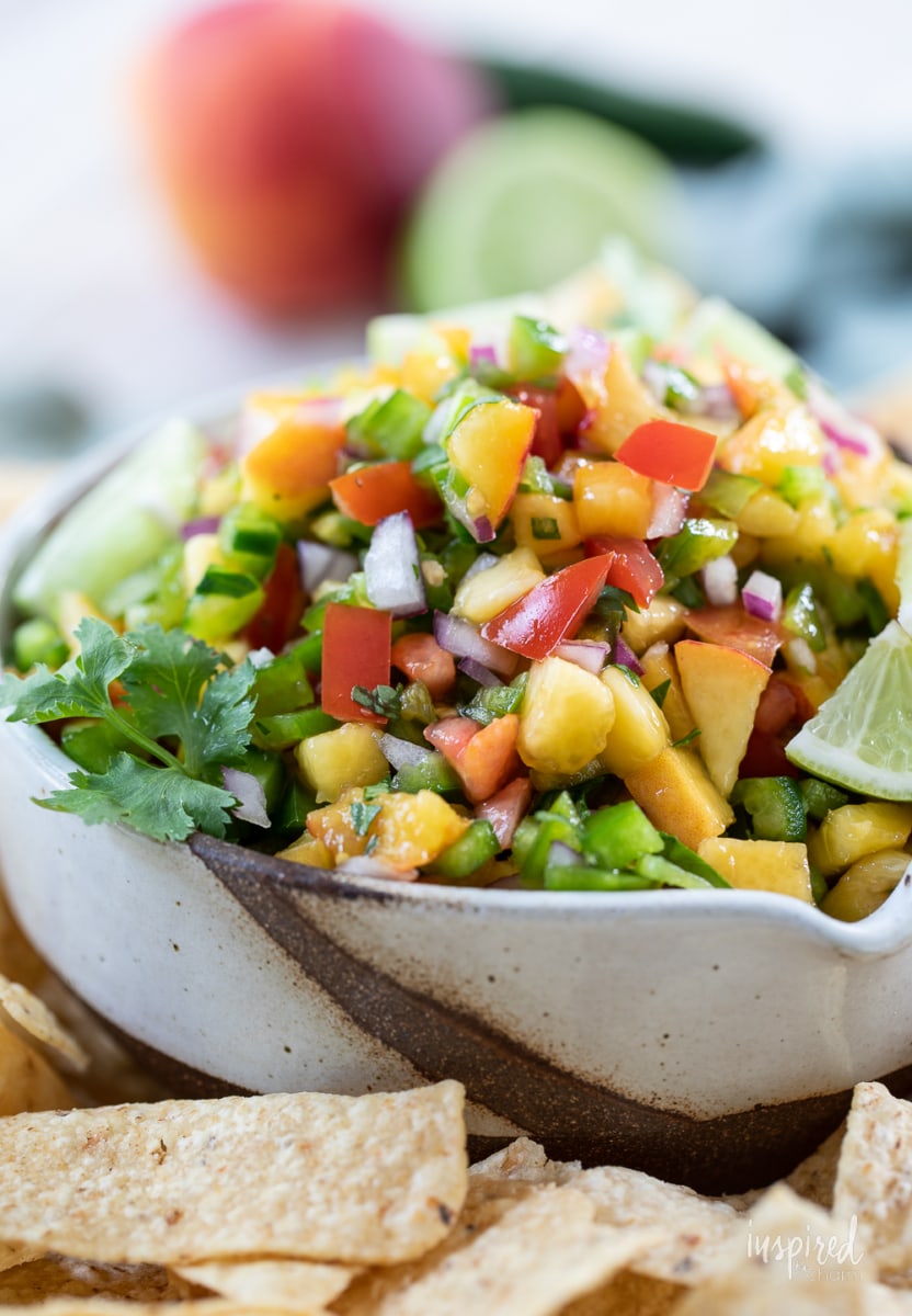 Spicy Peach Salsa in a bowl with tortilla chips.