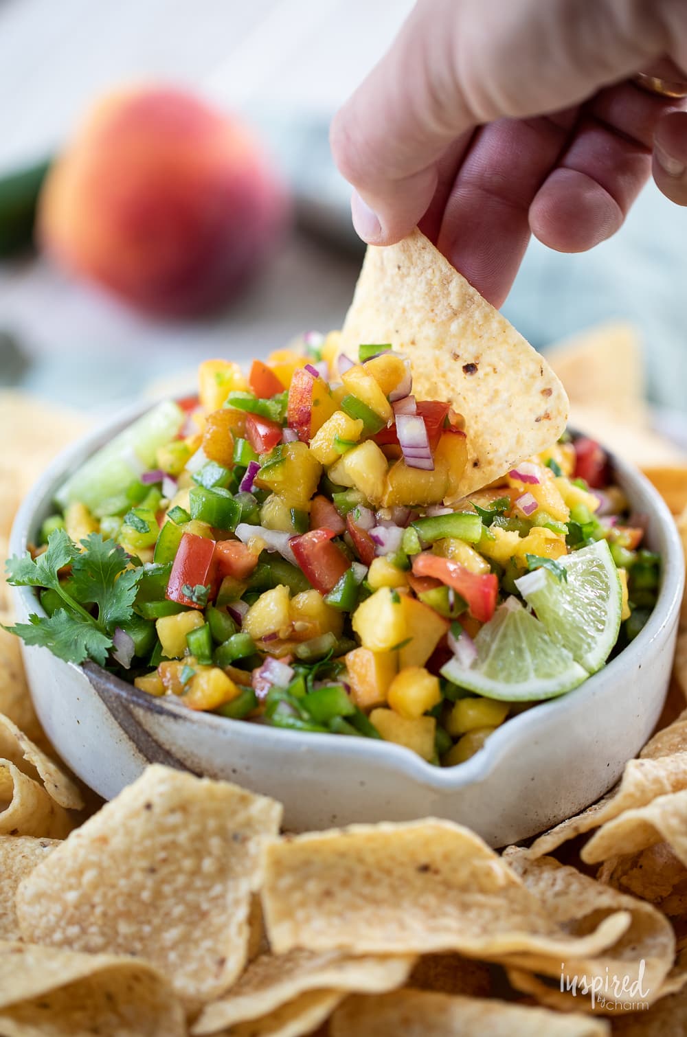 Spicy Peach Salsa in a bowl with tortilla chips.