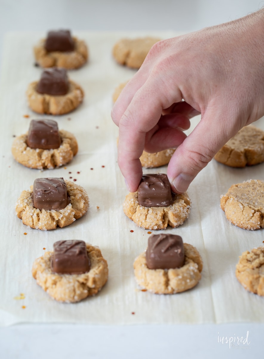 adding mini candy bars to cookies.