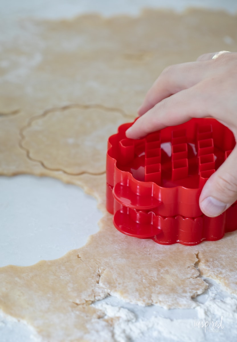 cutting out pie crust into a circle.