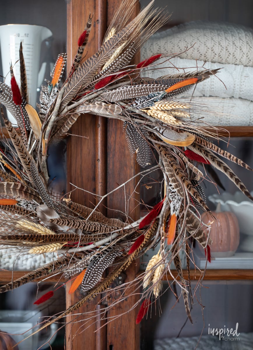 DIY Feather Wreath for Fall on cabinet.