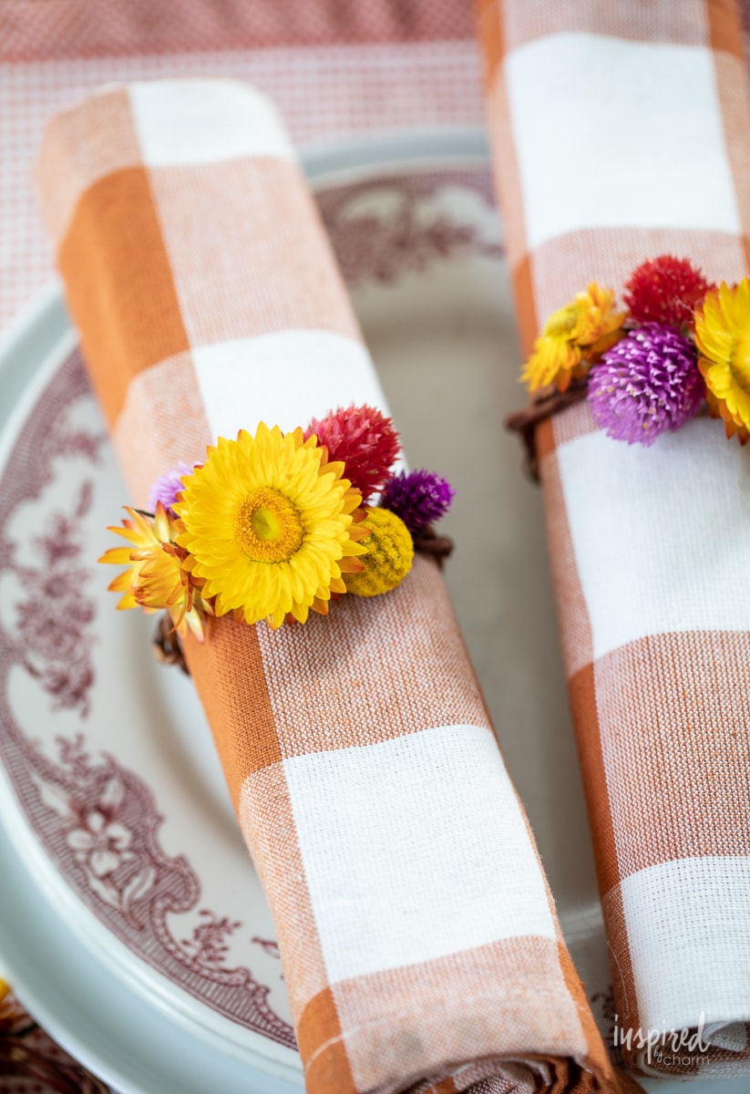 DIY Dried Flower Napkin Rings on napkins on plates.