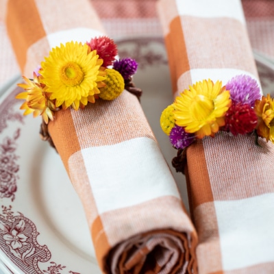 DIY Dried Flower Napkin Rings on napkins on plates.