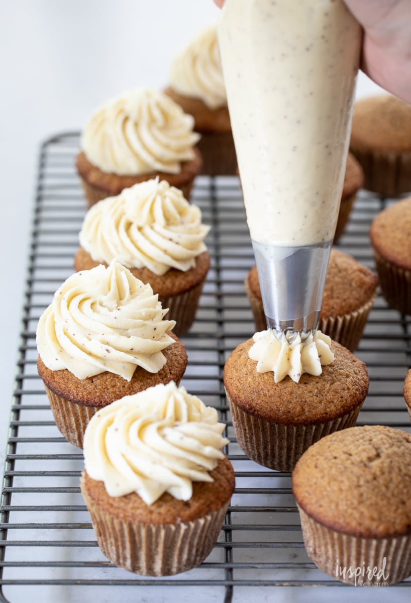 piping frosting onto cupcakes.
