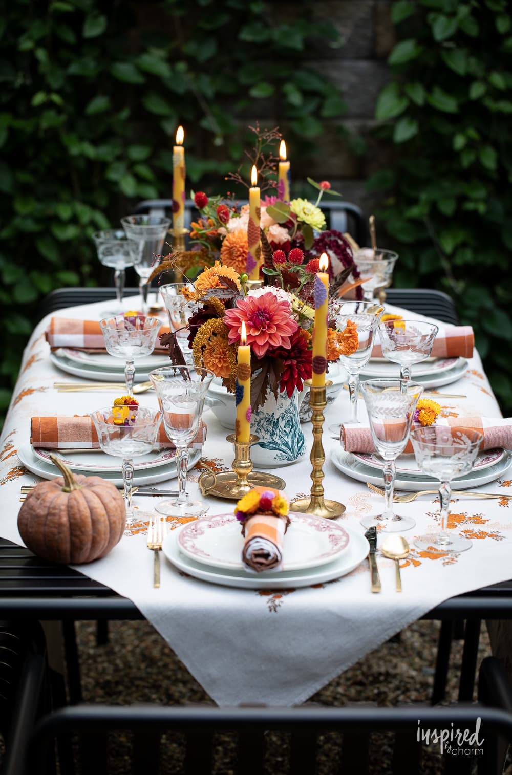 a table set outside with flowers and vintage decor. 