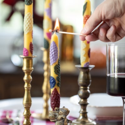 lighting taper candles on a table.