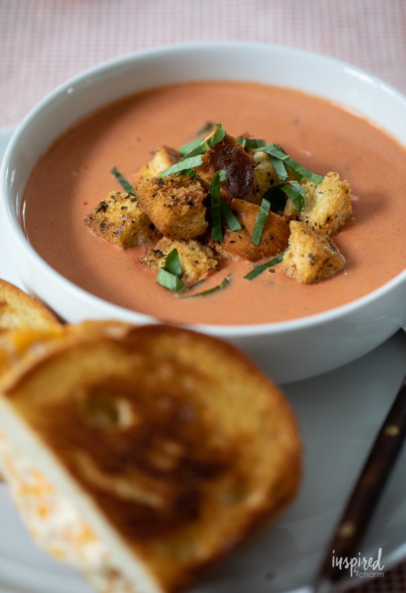 Tomato Basil Soup in bowls with grilled cheese.