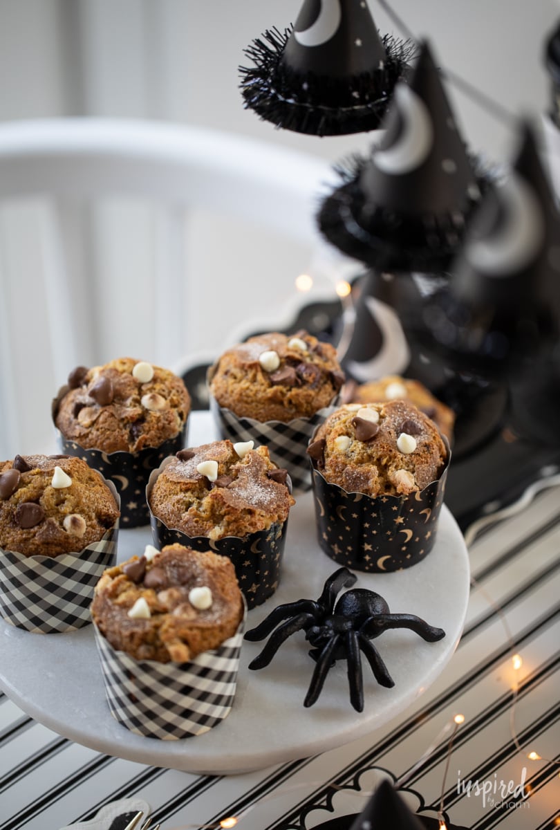 Chocolate Chip Pumpkin Muffins on cake stand with halloween decor.