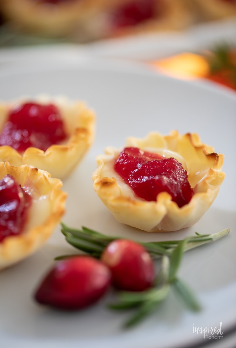 Cranberry Brie Bites on a plate with rosemary.