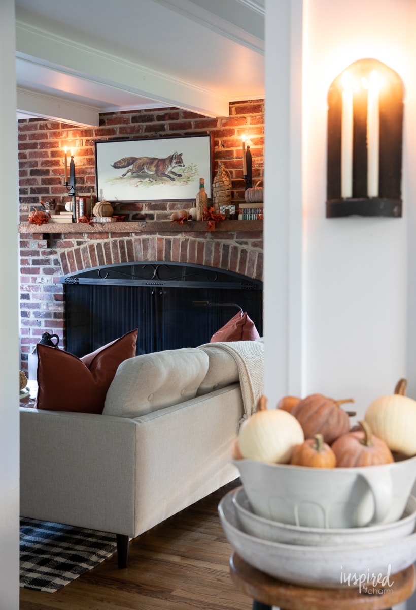 fall mantel decor with fox painting and candles.