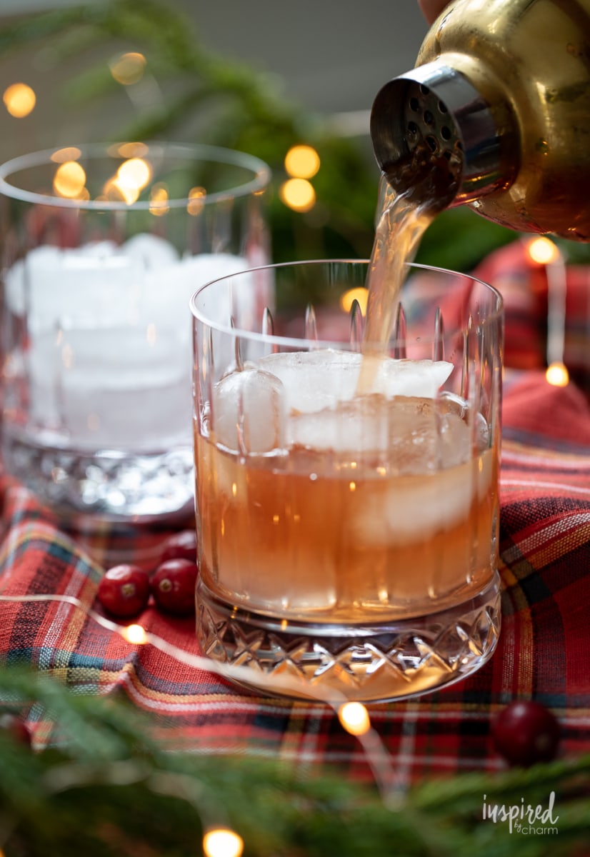 pouring Cranberry Rye Holiday Cocktail into glass with ice.