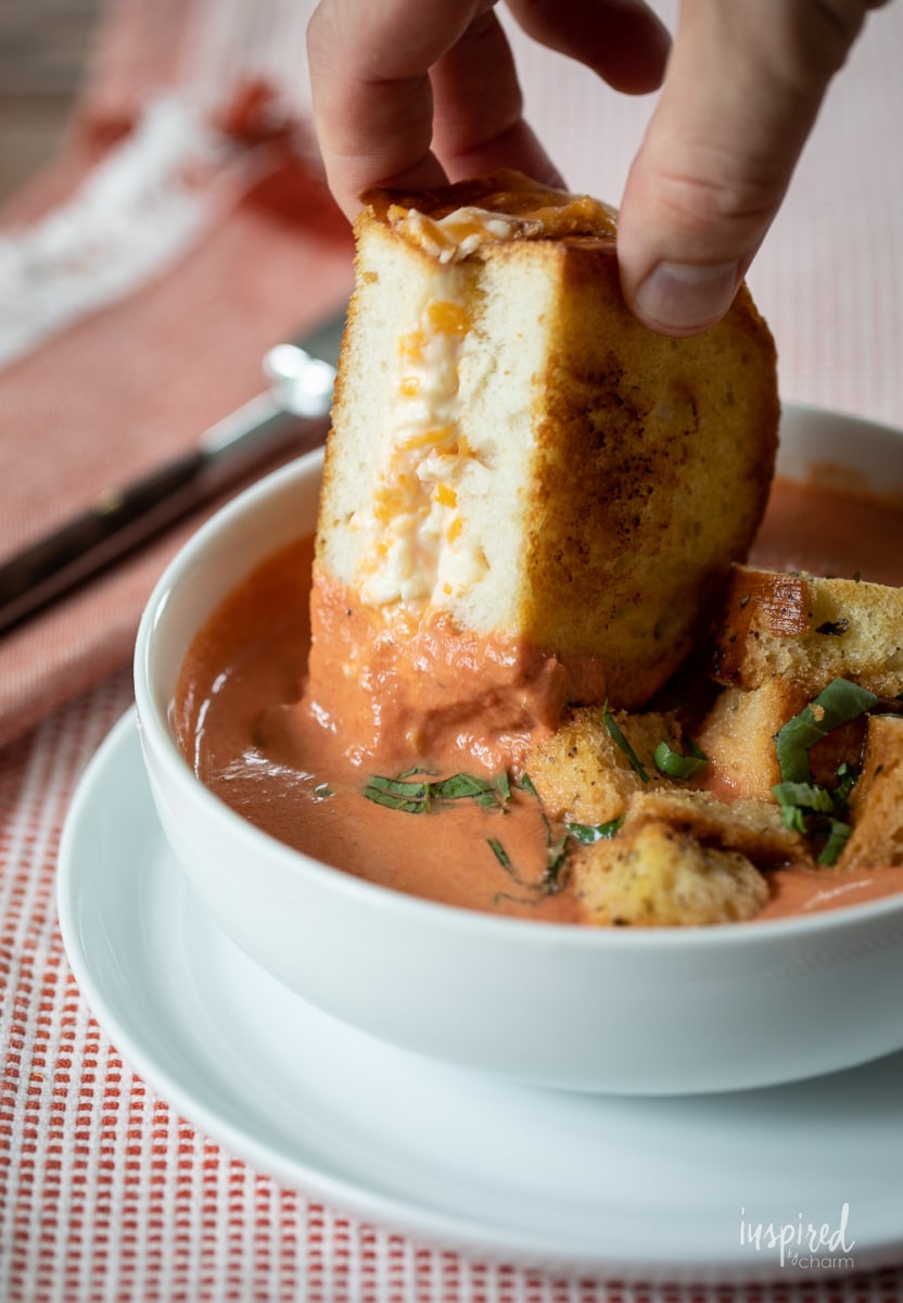 dipping Ultimate Grilled Cheese into tomato basil soup.