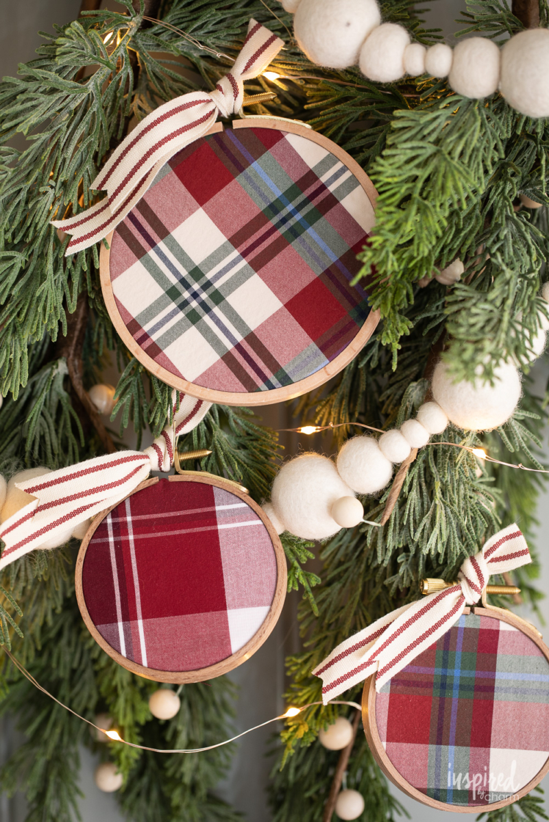 DIY Embroidery Hoop Christmas Ornaments on pine with lights and felt garland.