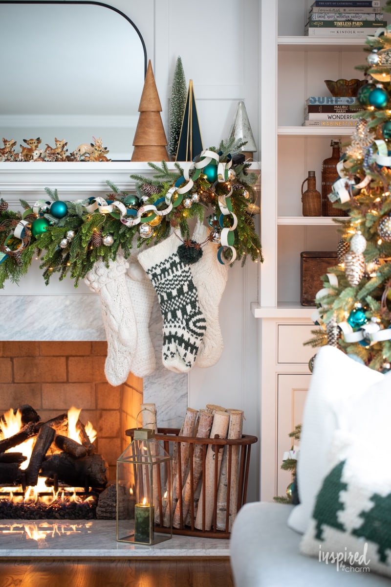close up of christmas mantel decor with garland and stockings.