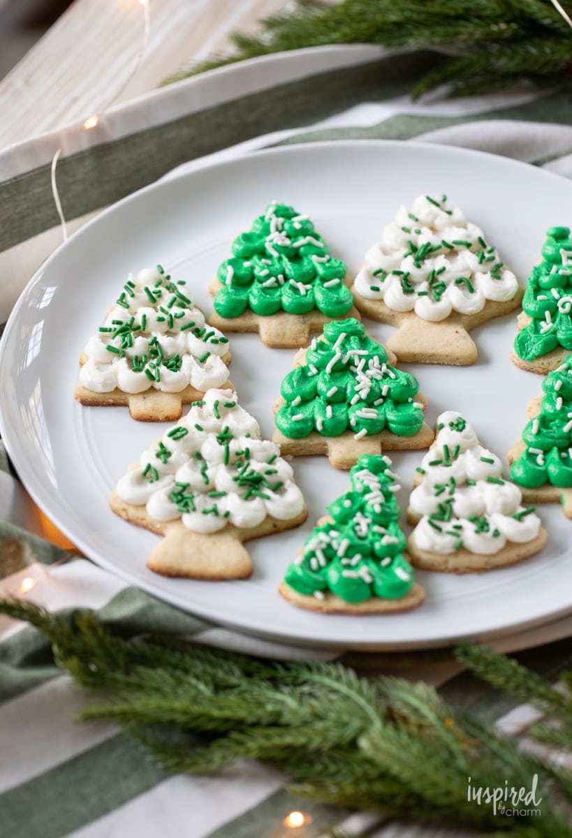 pine tree shaped frosted almond sugar cookies on a plate.