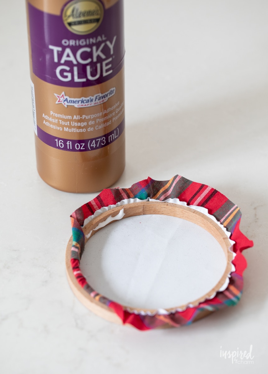 adding glue to embroidery hoop ornament.