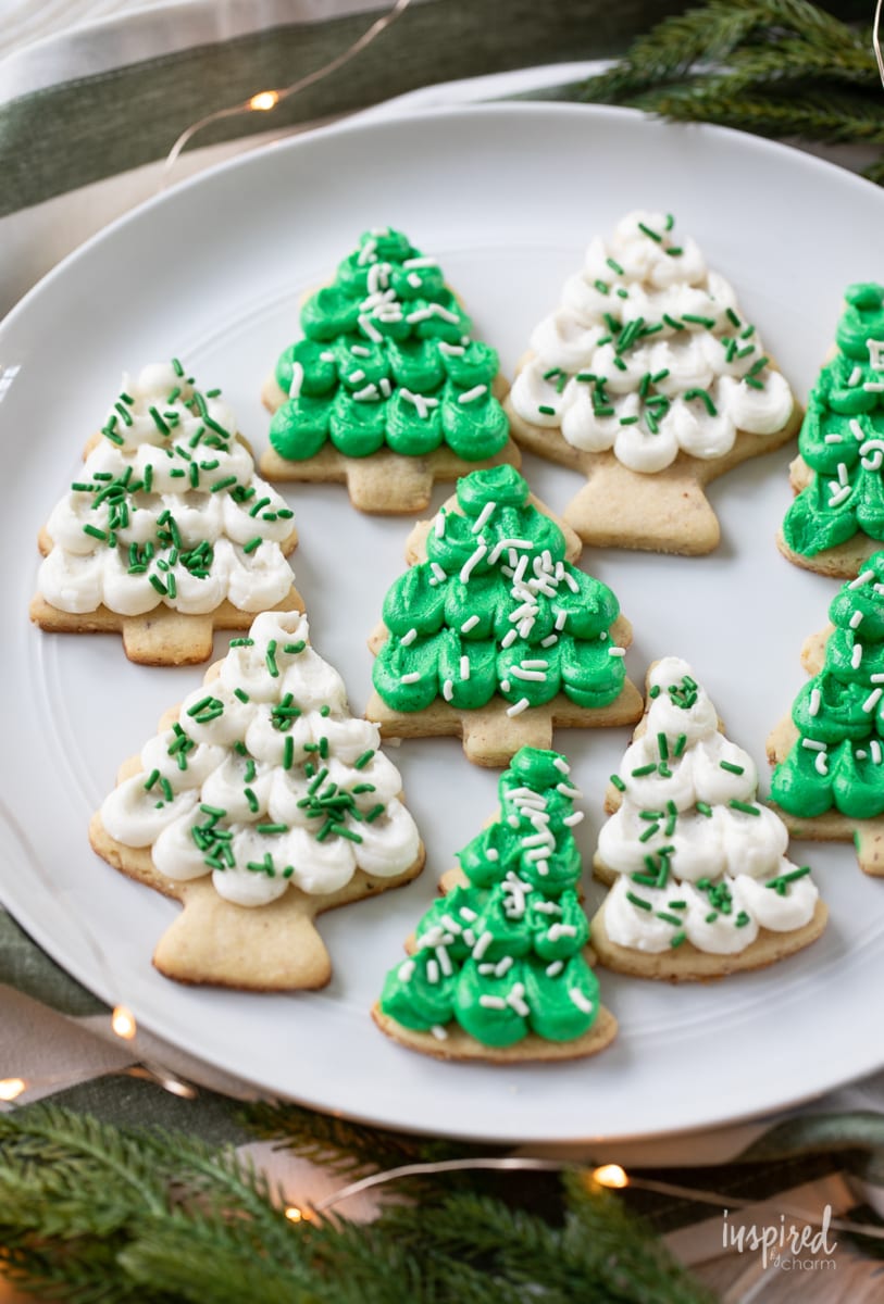 pine tree shaped frosted almond sugar cookies on a plate.
