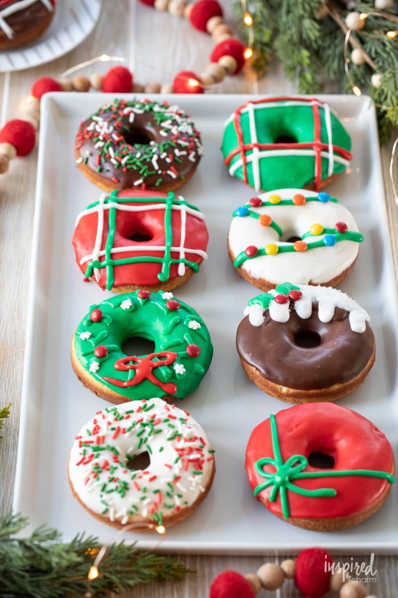 eight christmas donuts on a plate. 