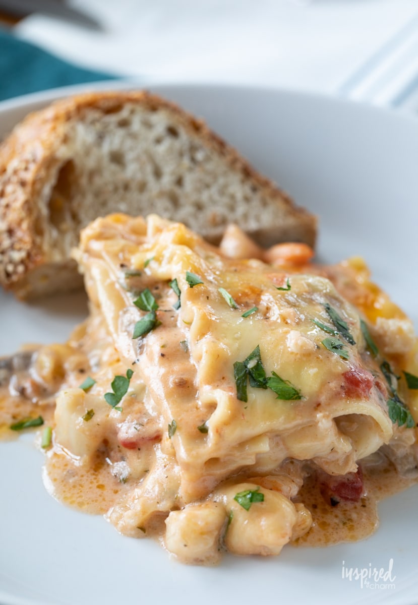 seafood lasagna on plate with bread.