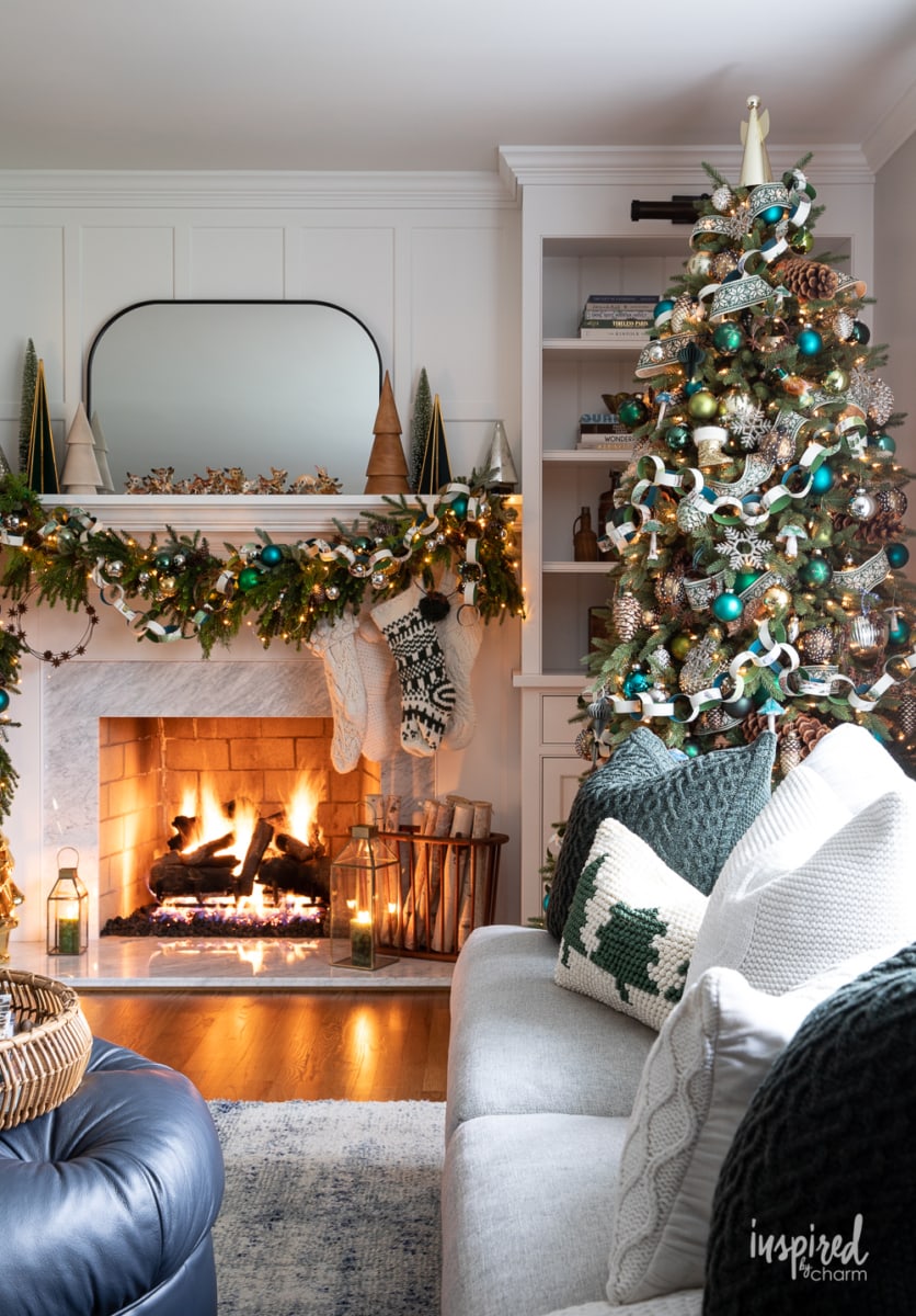 decorated christmas tree in front of a fireplace.