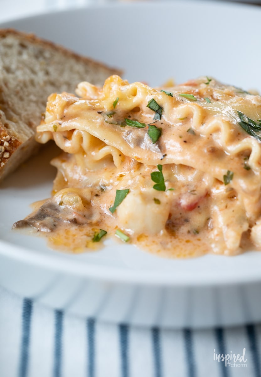seafood lasagna on plate with bread.