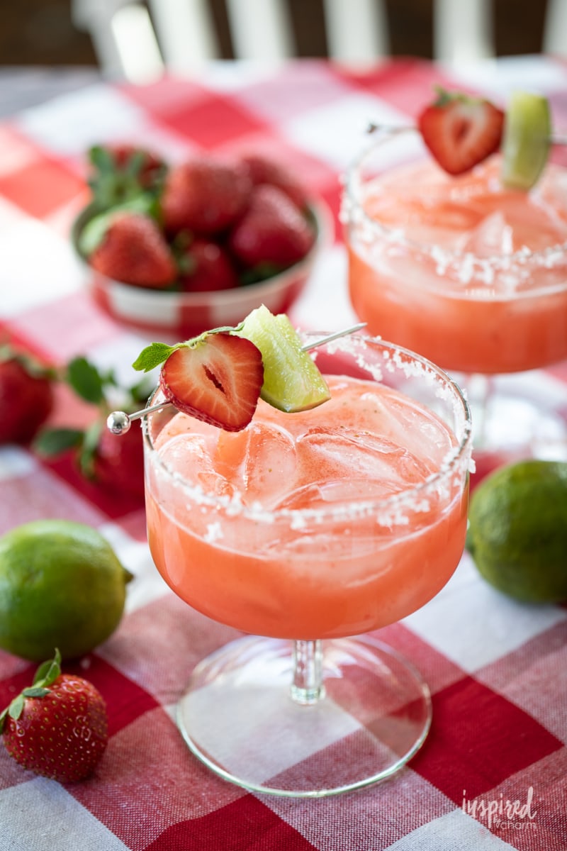 two strawberry margaritas on a table.