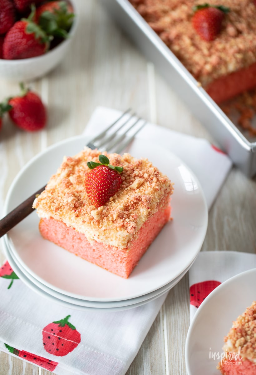 slice of strawberry crunch cake on a plate on a napkin.