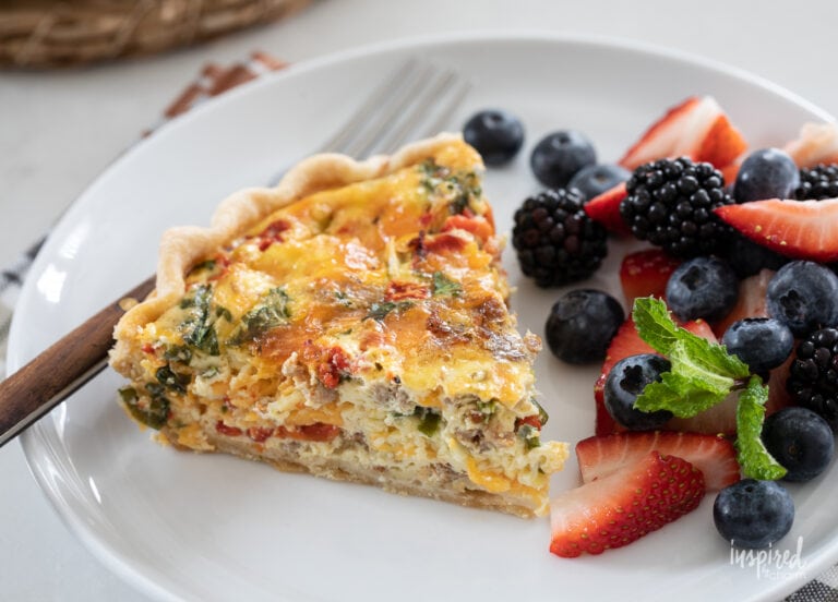 red pepper and sausage quiche on a plate with fresh berries.