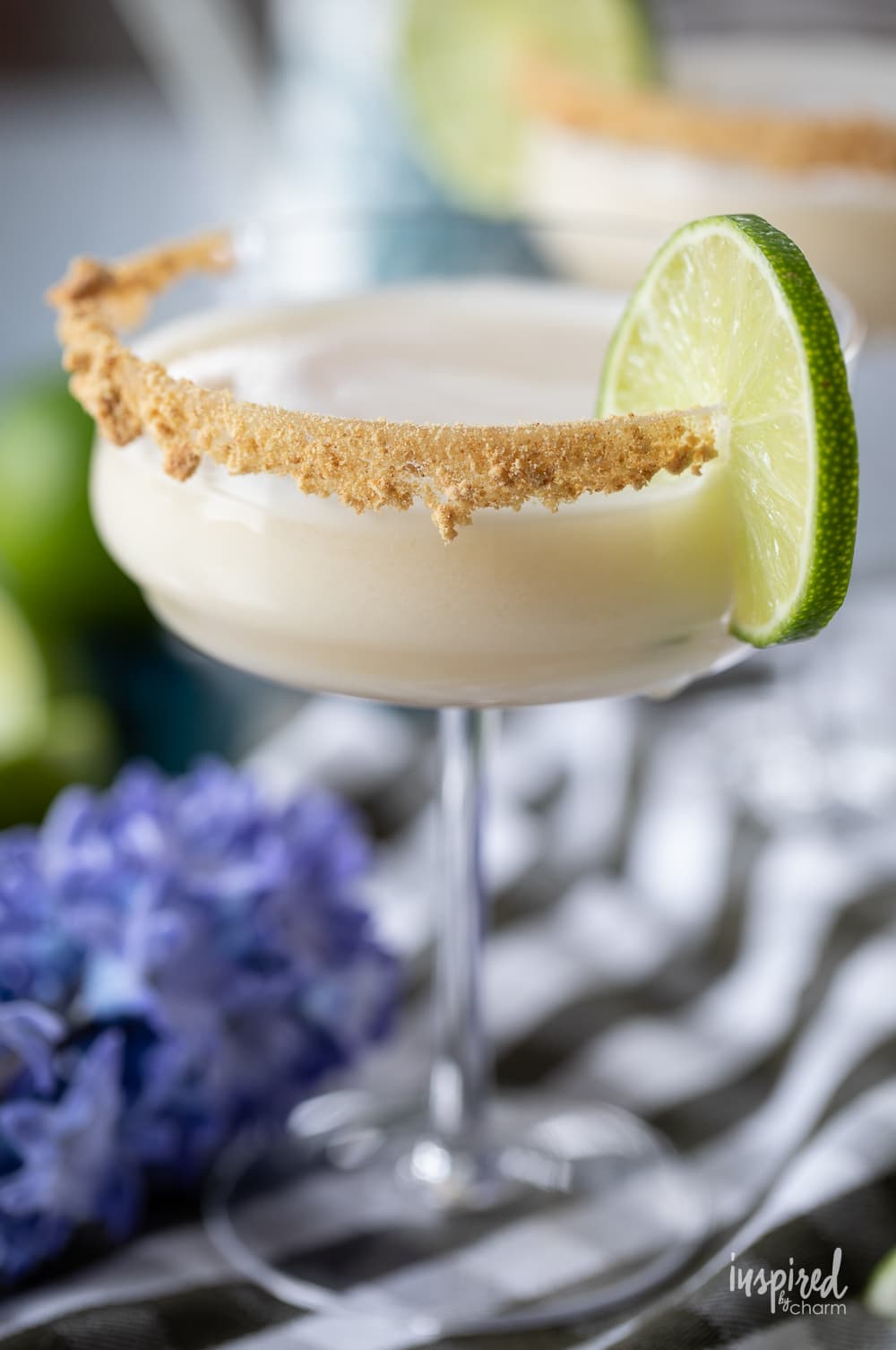 key lime pie martini in a glass with a lime garnish.