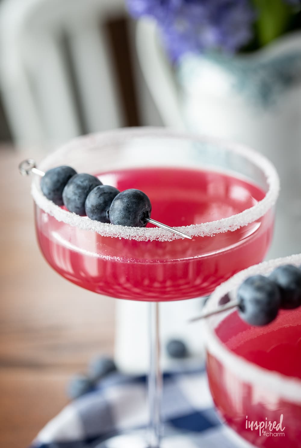 blueberry lemon drop martini in glass with blueberry garnish.