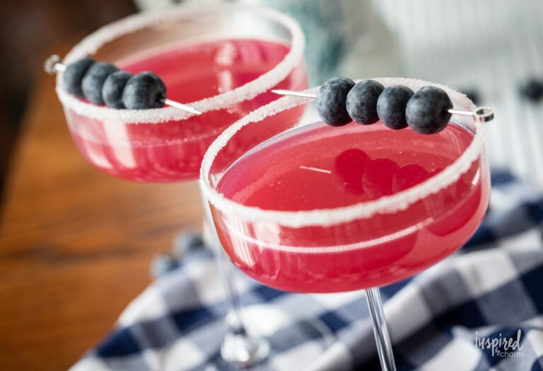 blueberry lemon drop martini in glass with blueberry garnish.